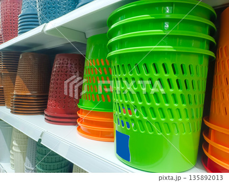 Stack of Bright Green Plastic Waste Bins and Storage Buckets on Retail Shelf 135892013