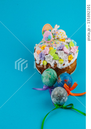 Easter cake with colorful decorations and eggs on a blue background 135892101