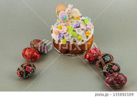 Colorful Easter cake with decorated eggs on gray surface Colorful Easter cake with decorated eggs on gray surface 135892109