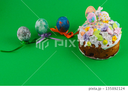 Easter cake and decorated eggs on a green spring background 135892124