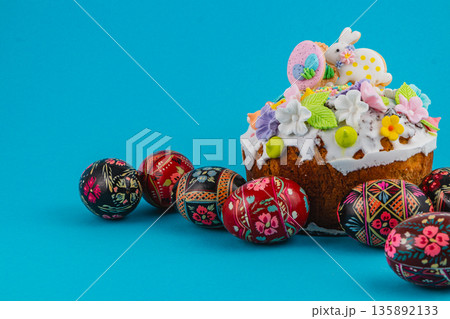 Easter cake with decorated eggs on blue background in spring season 135892133