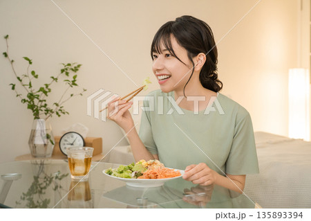 晩御飯を食べる一人暮らしの若いアジア人女性 晩御飯を食べる一人暮らしの若いアジア人女性 135893394