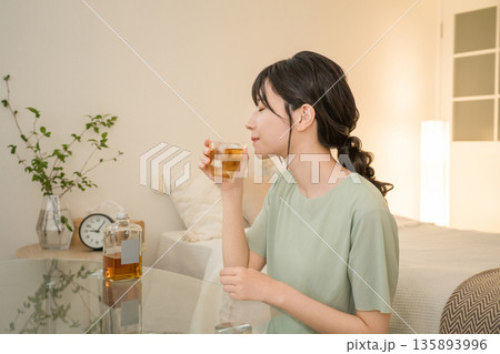 家の寝室で晩酌する若いアジア人女性(ウィスキー,家飲み,飲酒習慣) 家の寝室で晩酌する若いアジア人女性(ウィスキー,家飲み,飲酒習慣) 135893996