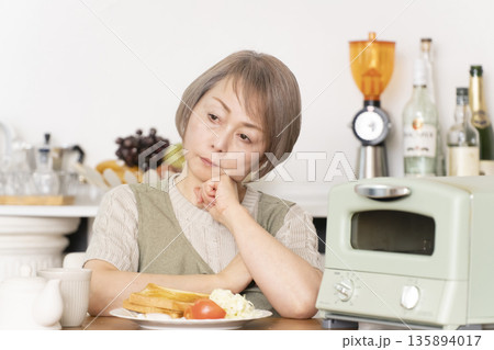 食欲不振に悩むシニア女性 食欲不振に悩むシニア女性 135894017