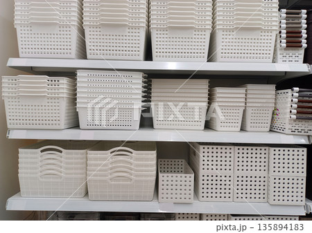 White Plastic Storage Baskets and Bins Arranged on Retail Shelves for Home Organization 135894183