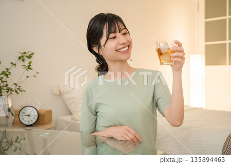 自宅の寝室で晩酌をする若いアジア人女性(家飲み,ほろ酔い,宅飲み,酒飲み) 自宅の寝室で晩酌をする若いアジア人女性(家飲み,ほろ酔い,宅飲み,酒飲み) 135894463