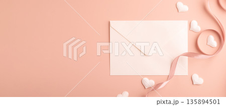 White envelope with ribbon and hearts on pastel background White envelope with ribbon and hearts on pastel background 135894501