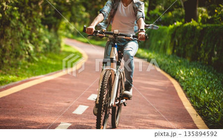 Fitness woman cycling in the park Fitness woman cycling in the park 135894592