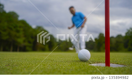 Golf ball is on a green lawn in a beautiful golf course with morning sunshine. Golf ball is on a green lawn in a beautiful golf course with morning sunshine. 135894982
