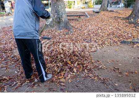 落ち葉だらけの公園の掃除をしている男性 135895012