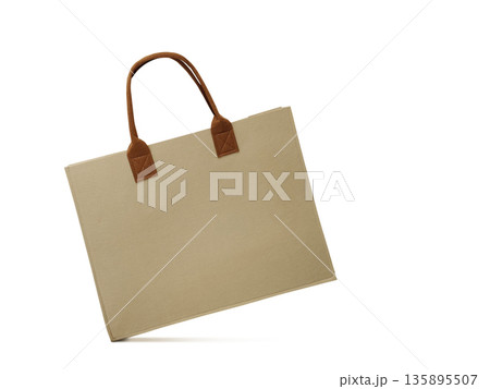 A brown recycled paper bag is stylishly arranged against a white background. A brown recycled paper bag is stylishly arranged against a white background. 135895507