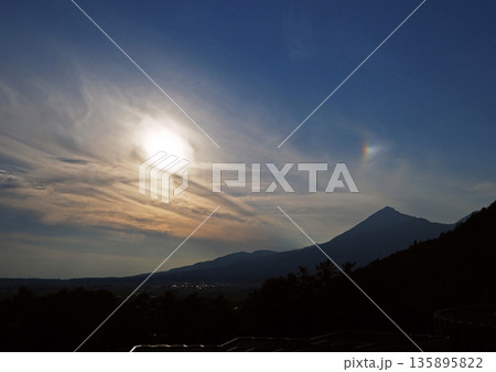 磐梯山の夕景。輝く夕日で山の上空に彩雲が現れ、青空に印象的で綺麗だ。 磐梯山の夕景。輝く夕日で山の上空に彩雲が現れ、青空に印象的で綺麗だ。 135895822