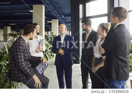 Diverse business team smiling in modern office during productive meeting 135896028