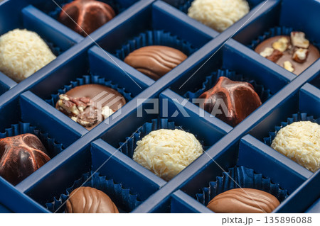 Assorted chocolate pralines in blue gift box close up Assorted chocolate pralines in blue gift box close up 135896088