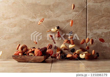 Mix of dried fruits and nuts in motion. Mix of dried fruits and nuts in motion. 135896179