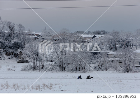 雪に覆われた里山の住宅地とバイク通勤 冬の地方暮らし 雪に覆われた里山の住宅地とバイク通勤 冬の地方暮らし 135896952