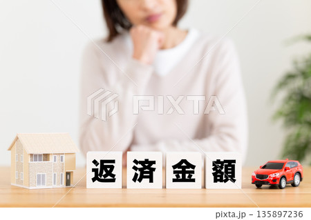 返済金額のブロックと悩むミドル女性 135897236