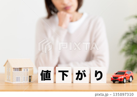 値下がりのブロックと悩むミドル女性 135897310