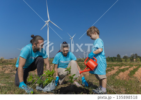 Family helping planting tree in garden for save world on wind turbine field background 135898518