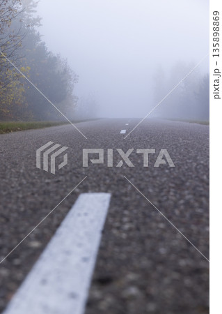 cloudy weather with a gray nondescript sky, thick fog in the morning due to climate change, a narrow country road with trees on the edge of the road in the autumn season, cloudy weather with a gray nondescript sky, thick fog in the morning due to climate change, a narrow country road with trees on the edge of the road in the autumn season, 135898869