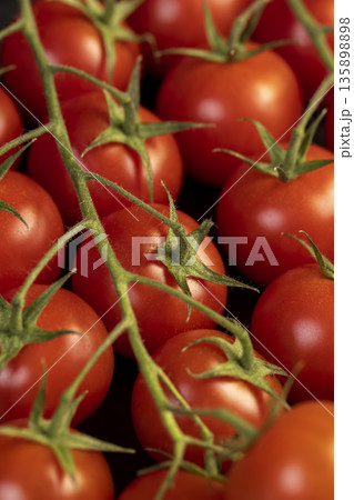 ripe red tomatoes on a black slate board, sweet fresh round tomatoes lie on a black board after harvesting 135898898