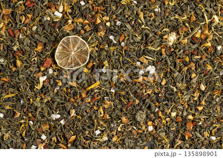natural green tea with added flavors and pieces of fruit and cut dried green limes , bright large dry lime slices and green tea with pieces of fruit 135898901