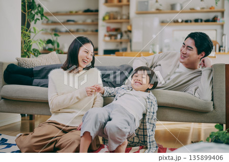 リビングでくつろぐ家族 135899406