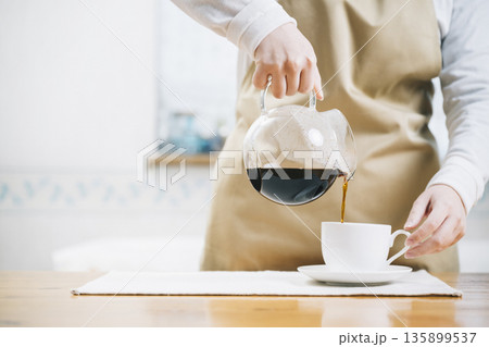 コーヒーカップにコーヒーを注ぐ女性 コーヒーカップにコーヒーを注ぐ女性 135899537