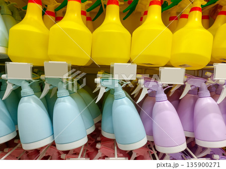 Rows of Plastic Spray Bottles for Gardening and Household Cleaning in Pastel Colors 135900271