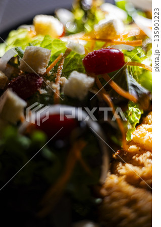 Cross Up Fried Chicken Salad With Mixed Veggies, A crispy photo of fried chicken salad, crispy chicken pieces top fresh greens and vegetables,  healthy fast food or balanced meal documentary. 135901223