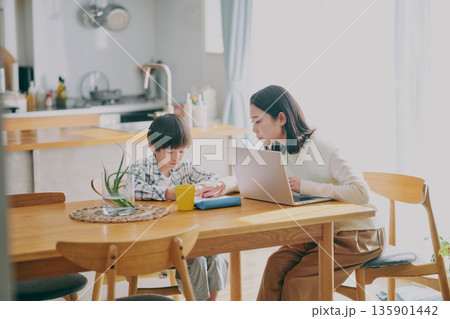 勉強する子供とリモートワーク中の親 勉強する子供とリモートワーク中の親 135901442
