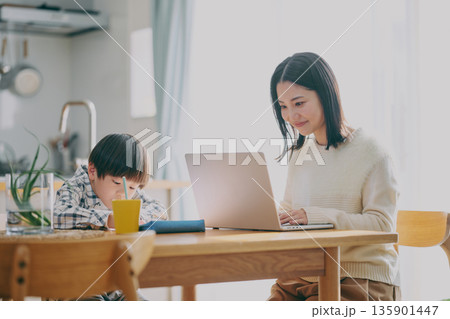勉強する子供とリモートワーク中の親 135901447