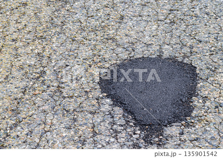Fresh asphalt patch. Roadwork. Patched asphalt road. Asphalt patch temporary road repair work Fresh asphalt patch. Roadwork. Patched asphalt road. Asphalt patch temporary road repair work 135901542