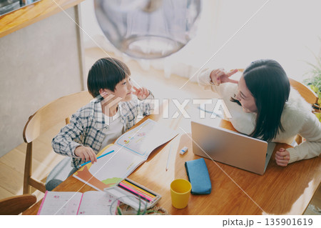 勉強する子供とリモートワーク中の親 135901619