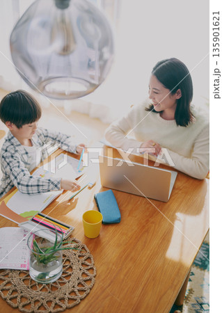 勉強する子供とリモートワーク中の親 135901621