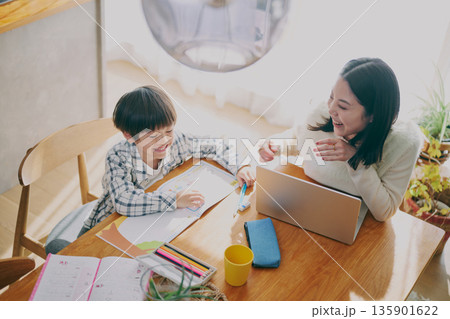勉強する子供とリモートワーク中の親 勉強する子供とリモートワーク中の親 135901622