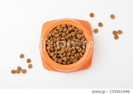 Dry pet food granules in feeding bowl on white background Dry pet food granules in feeding bowl on white background 135901946