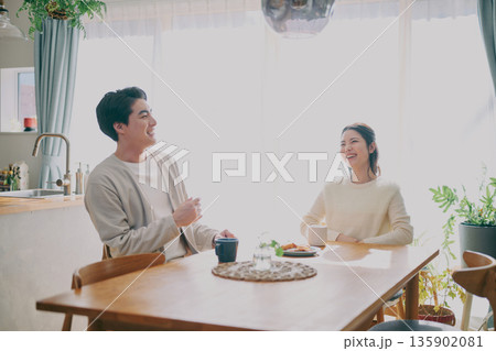 ダイニングでくつろぐ夫婦 135902081