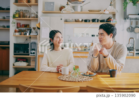 ダイニングでくつろぐ夫婦 135902090