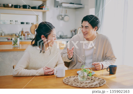 ダイニングでくつろぐ夫婦 135902163