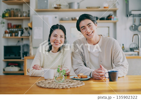 ダイニングでくつろぐ夫婦 135902322