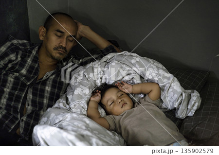 Dad Sleeping Beside Young Child In Daytime, A tender ad photo of dad sleeping beside young child in daytime, peaceful faces in soft sun rays, perfect for family bond or gentle rest documentary. Dad Sleeping Beside Young Child In Daytime, A tender ad photo of dad sleeping beside young child in daytime, peaceful faces in soft sun rays, perfect for family bond or gentle rest documentary. 135902579