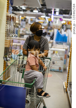 Mom And Child Shop With Cart in Market, A lively ad photo of mom and child shopping with cart in market, hands reaching produce , perfect for family grocery campaign or joyful market documentary. Mom And Child Shop With Cart in Market, A lively ad photo of mom and child shopping with cart in market, hands reaching produce , perfect for family grocery campaign or joyful market documentary. 135902584