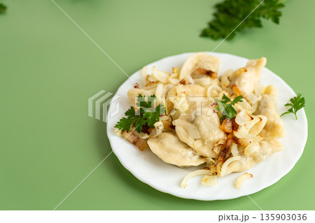 Traditional Ukrainian varenyky with golden onion and herbs 135903036