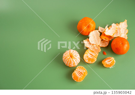 Bright juicy mandarin fruits arranged with natural citrus peel Bright juicy mandarin fruits arranged with natural citrus peel 135903042