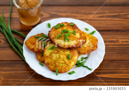 Traditional potato pancakes with fresh herbs on wooden table Traditional potato pancakes with fresh herbs on wooden table 135903053