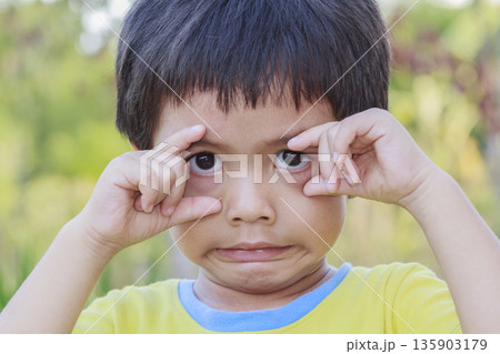 Portrait of happy cute Asian Thai little boy rounding his eyes with his fingers Portrait of happy cute Asian Thai little boy rounding his eyes with his fingers 135903179