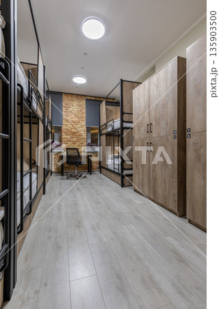 Vertical shot of a loft hostel dormitory with bunk beds and wooden lockers 135903500