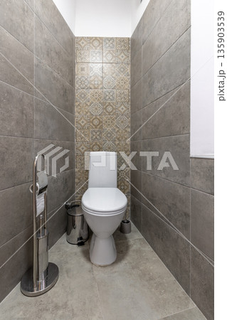 Modern minimalist restroom with white toilet and grey stone tiling 135903539