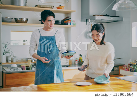 食器を片付ける夫婦 135903664